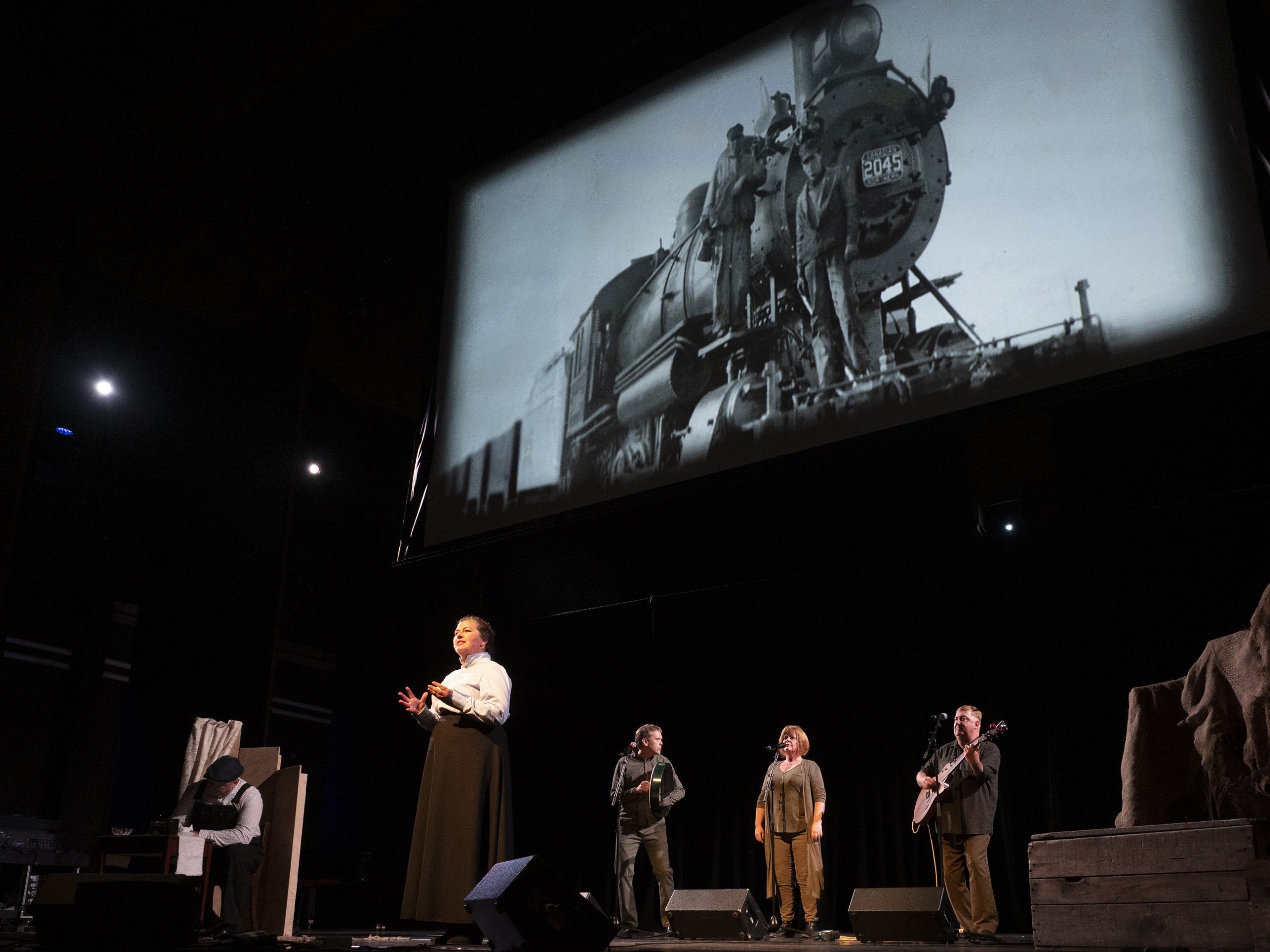 Image of 100 Years From Now performed on stage with musicians and actors